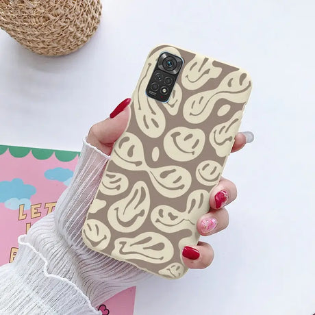 a woman holding a phone case with a pattern on it