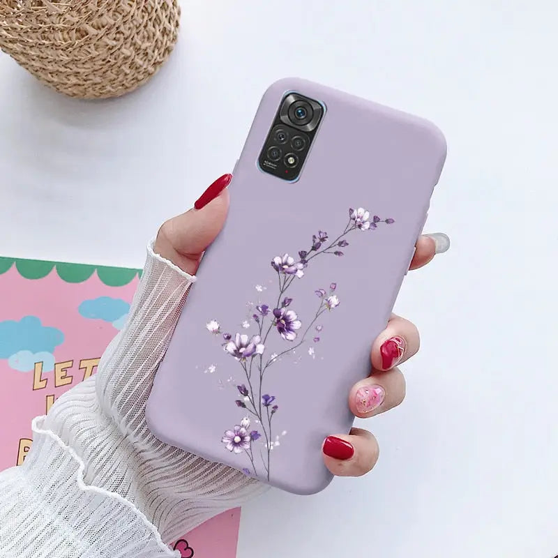 a woman holding a phone case with flowers on it