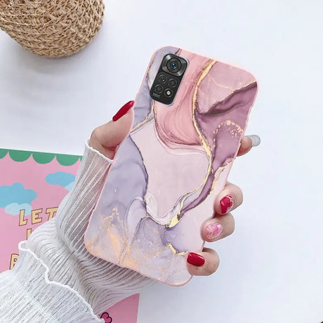 a woman holding a phone case with a marble pattern