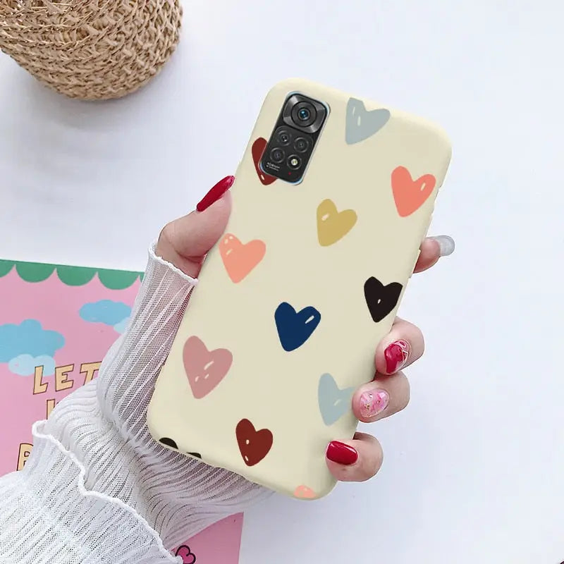 a woman holding a phone case with hearts on it