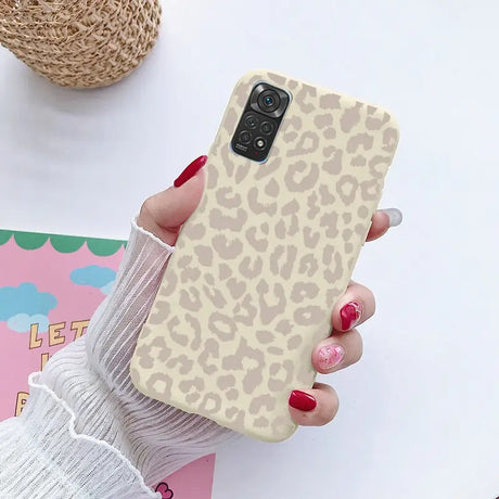 a woman holding a phone case with a leopard print