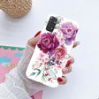 a woman holding a phone case with flowers on it