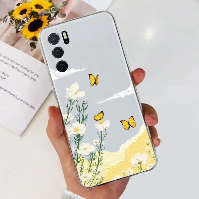 a woman holding a phone case with flowers and butterflies