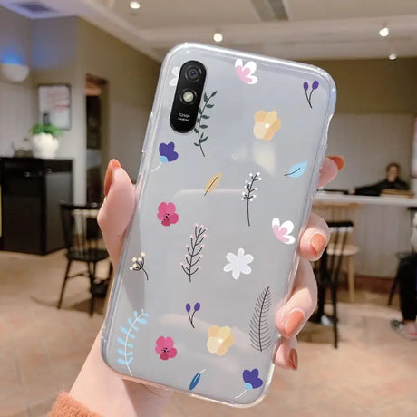 a woman holding a phone case with flowers on it