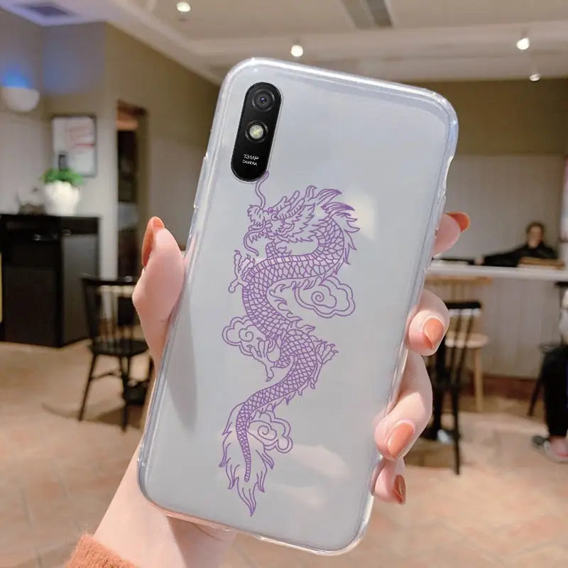 a woman holding up a phone case with a purple dragon on it