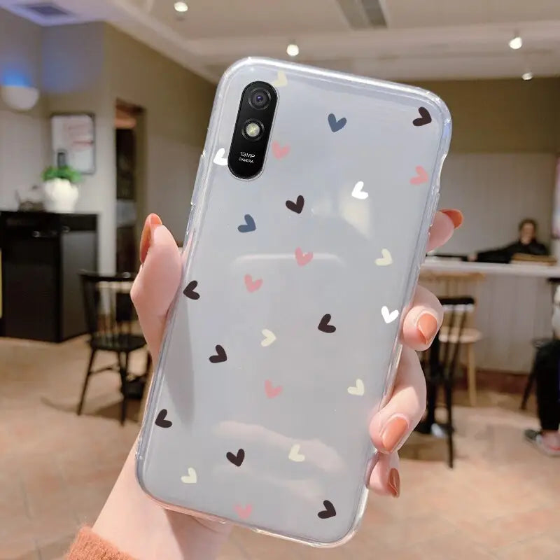 a woman holding up a phone case with hearts on it