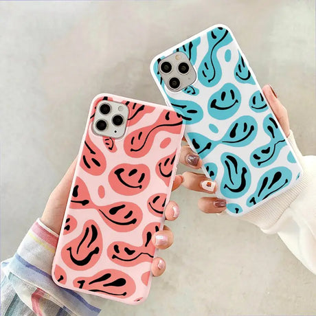 a pair of hands holding up a pink and blue phone case