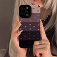 a woman holding up a phone case with hearts on it