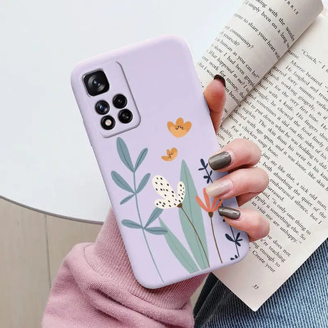 a woman holding a phone case with flowers on it