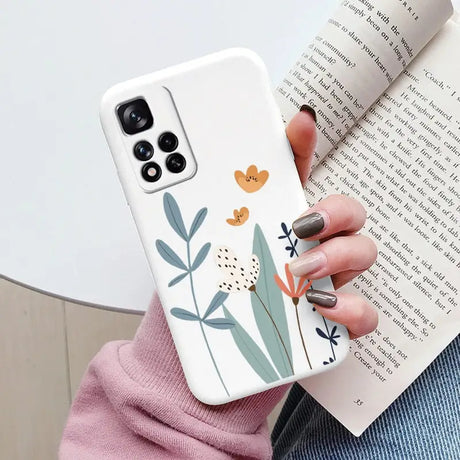 a woman holding a book and holding a phone case