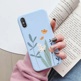 a woman holding a phone case with a flower design