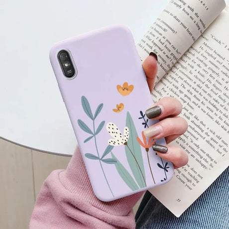 a woman holding a phone case with flowers on it