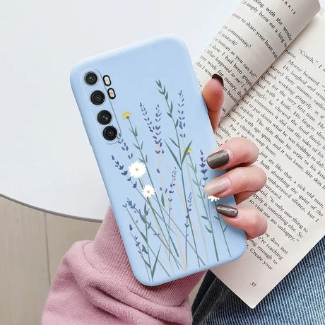 a woman holding a phone case with a flower design