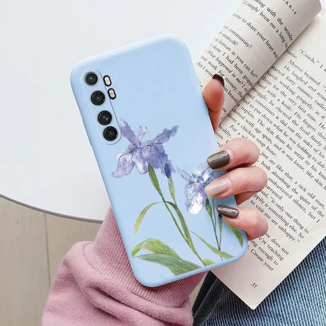 a woman holding a phone case with a flower on it