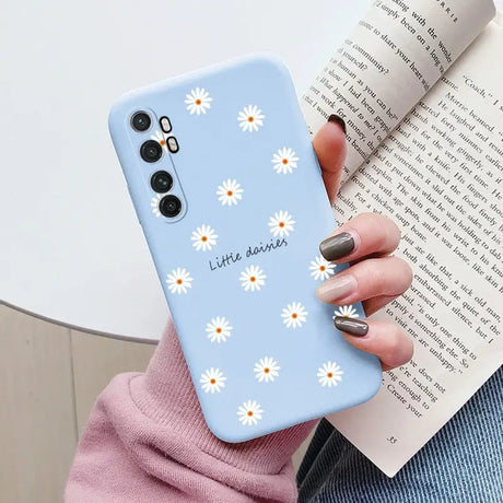 a close up of a person holding a phone case with daisies on it