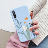 a woman holding a phone case with flowers on it