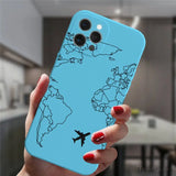 a woman holding up a phone case with a world map on it