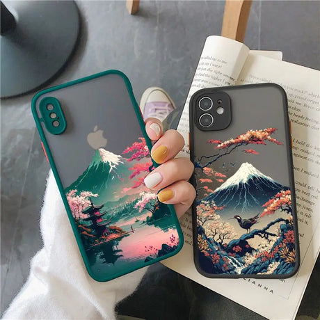 a woman holding a phone case with a mountain scene