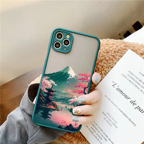 a woman holding a phone case with a mountain scene