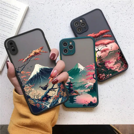 a woman holding a phone case with a painting on it