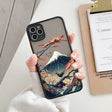 a woman holding a phone case with a mountain scene