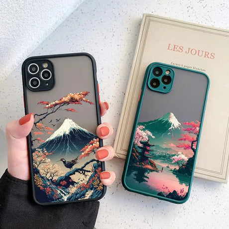 a woman holding a phone case with a mountain scene