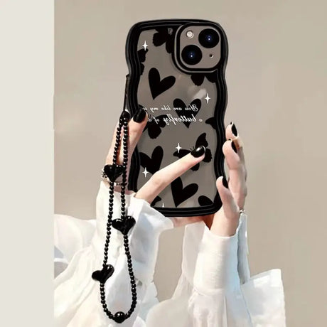 a woman holding up a phone case with a heart pattern