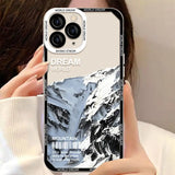 a woman holding up a phone case with a picture of a mountain