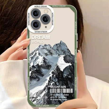 a woman holding up a phone case with a mountain scene