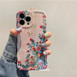 a woman holding a phone case with flowers on it