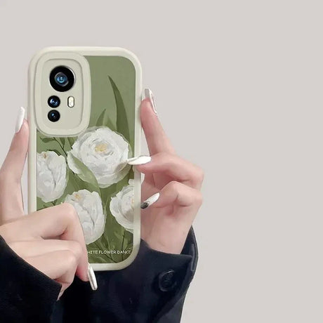 a woman holding a phone case with flowers on it