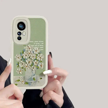 a woman holding a phone case with flowers on it