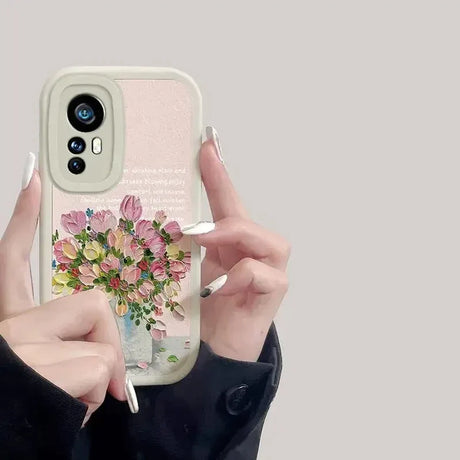 a woman holding a phone case with flowers on it