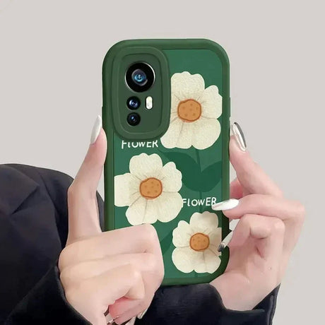 a woman holding a phone case with flowers on it