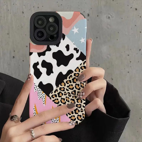 a woman holding a phone case with a leopard print