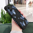 a woman holding a phone case with a blue flower pattern