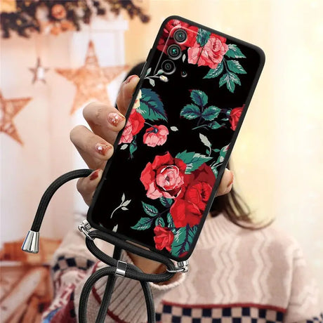 a woman holding a phone case with flowers on it