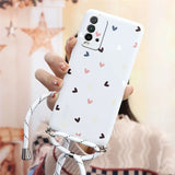 a woman holding a phone case with hearts on it