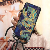a woman holding a phone case with a dragon design