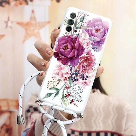 a woman holding a phone case with flowers on it