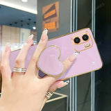 a woman holding a phone with a heart shaped ring