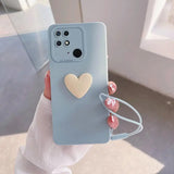 a woman holding a phone case with a heart on it