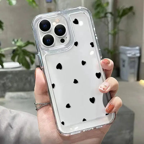 a woman holding a phone case with hearts on it