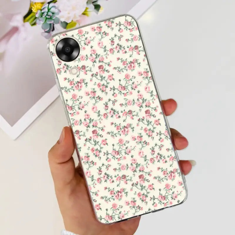 a woman holding a phone case with pink flowers on it