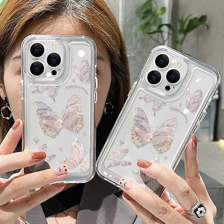 a woman holding up two iphone cases