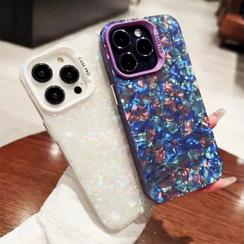 a woman holding a phone case with a blue and pink glitter design