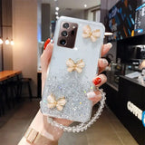 a woman holding a phone case with glitter butterflies on it