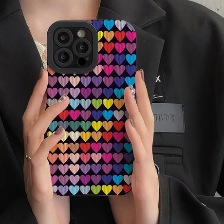 a woman holding a phone case with hearts on it