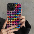 a woman holding up a phone case with hearts on it