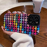 a woman holding a phone case with colorful hearts on it